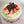 A strawberry cake with two layers, buttery cake with vanilla cream and fresh strawberries, with a decorative topper that reads 'To a real tough cookie, Happy Birthday!' on a pink floral background.